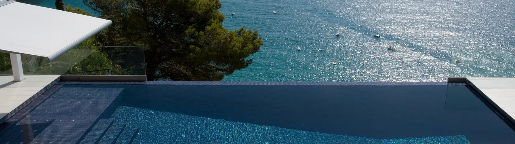 Mosaique verte dans une piscine au pied d’un mur blanc méditerranéen
