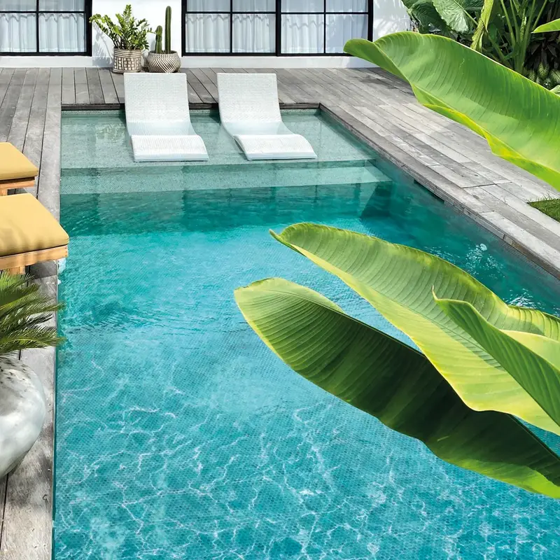 Belle luminosité sur la mosaique bleue de la piscine.