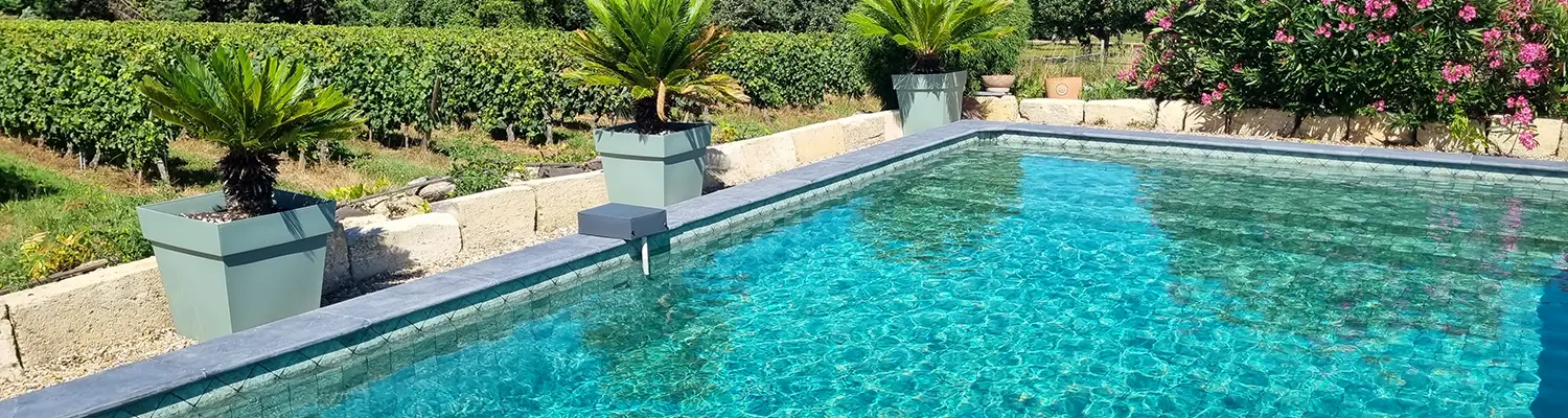 Mosaique verte dans une piscine au pied d’un mur blanc méditerranéen