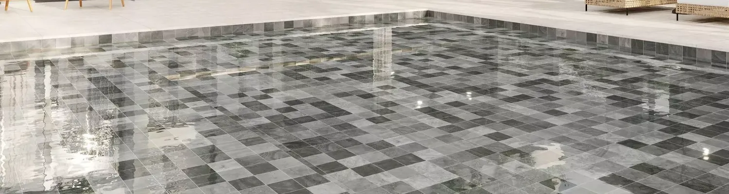 Mosaique verte dans une piscine au pied d’un mur blanc méditerranéen